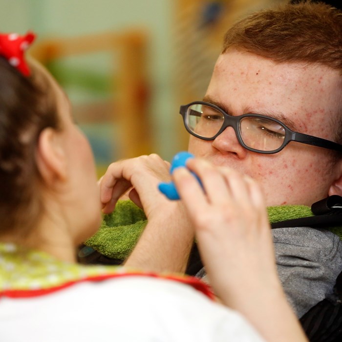 A boy interacting with a Demelza member of staff.