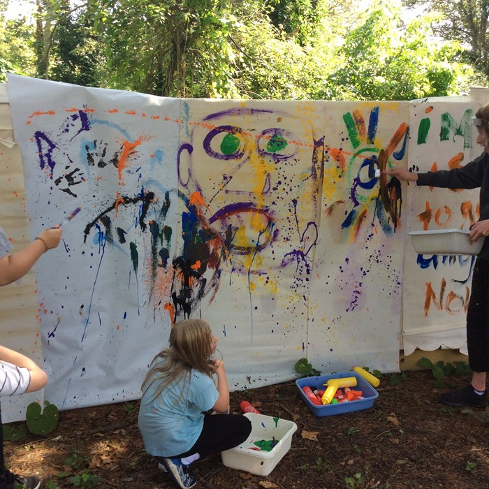 Children and young people enjoy a painting activity in the garden at East Sussex.