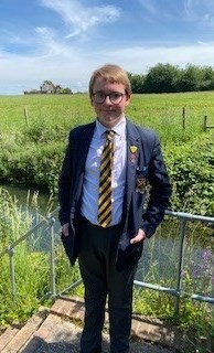 Demelza sibling, Jacob is smiling, wearing his school uniform.