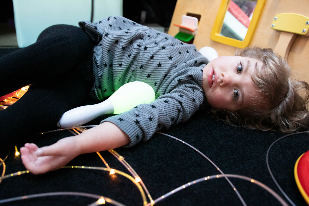 Matilda is laying on the flooring, enjoying sensory play.