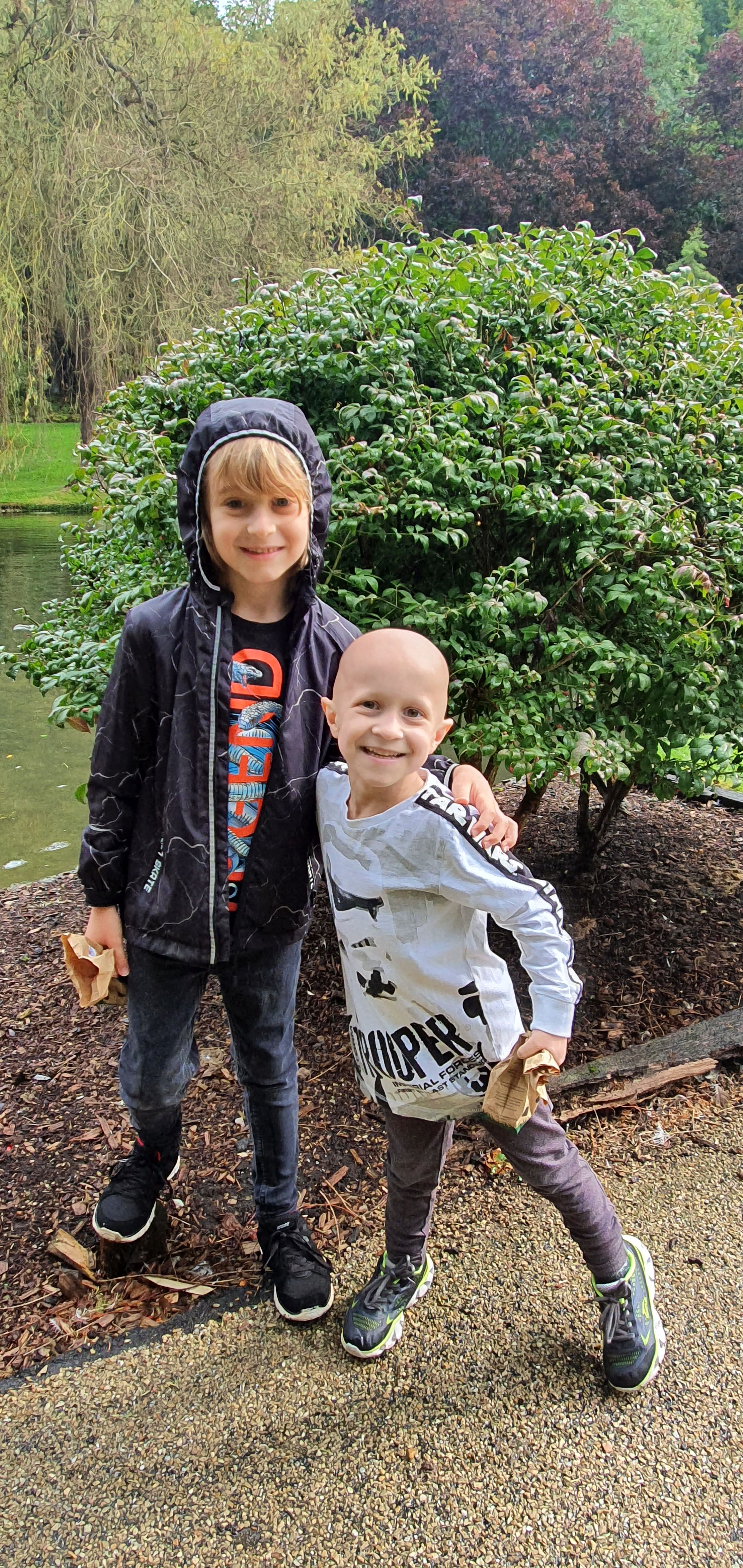 Zak and his brother, smiling, with their arms around each other.