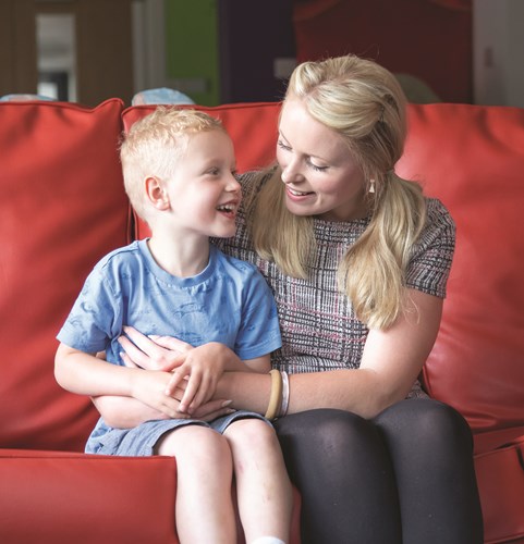 Child Ralph sitting next to his Mum on a sofa