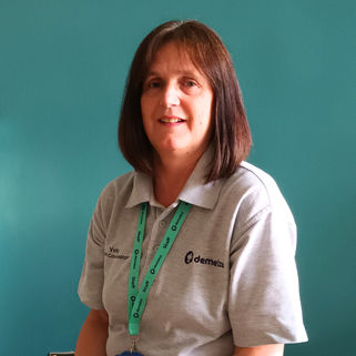 Healthcare Assistant Vicky sitting down smiling at the camera